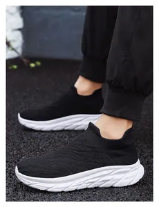 Close-up of black breathable knit sock sneaker with thick white sole on a man