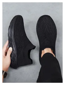Close-up of black breathable knit sneakers with chunky rubber soles and slip-on design