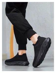 Detail view of black fly-knit sock sneakers with thick non-slip soles and breathable fabric