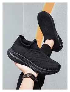 Detail of all-black knitted sock sneakers featuring textured wave patterns and thick soles