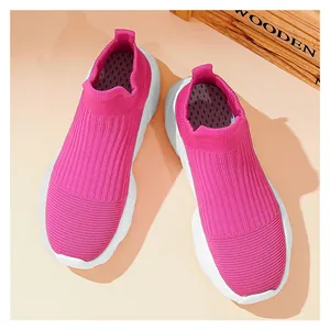 Vista dall'alto di sneakers rosa in maglia slip-on con suola bianca spessa e mesh