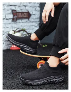 Detail view of black knit slip-on sneakers with geometric thick soles on a skateboard