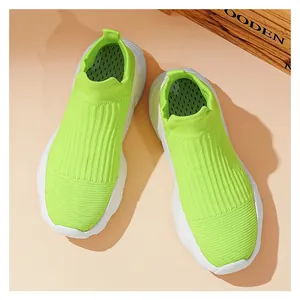 Vista macro di sneaker in maglia verde neon traspiranti con suole bianche ammortizzate