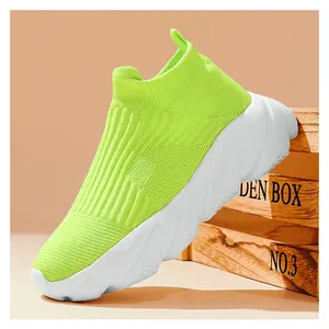 Vista laterale di sneaker a calzino verde lime con spessa suola platform bianca su legno