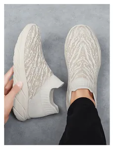 Close-up of beige knit sock sneakers with textured patterns and thick EVA cushioning soles