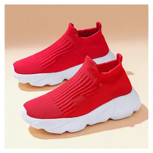 Dettaglio di sneaker in maglia rossa slip-on con spesse suole bianche ammortizzate e coste