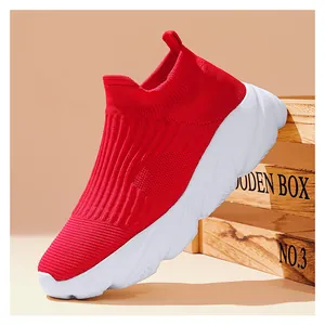 Dettaglio di sneaker slip-on in maglia rossa con suola spessa bianca e trama traspirante