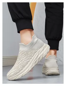 Detail of beige knit sock sneakers featuring a thick geometric sole on a model's feet