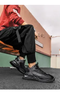 Nahaufnahme schwarzer Streetstyle-Sneaker mit dicker Dämpfungssohle und 23er Nummerierung
