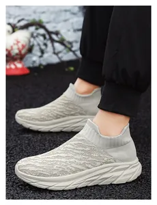 Detail of grey flyknit slip-on sneakers with wave pattern and chunky white rubber sole