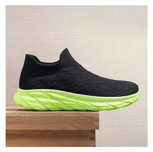 Close-up of black breathable knit sneakers with vibrant neon green chunky soles