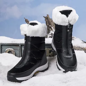 Detail van waterdichte snowboots met zwarte gewatteerde textuur en rits aan de voorkant