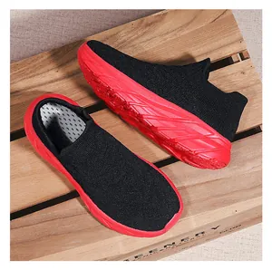Detail of black knit sock sneaker with thick red sole resting on a wooden crate