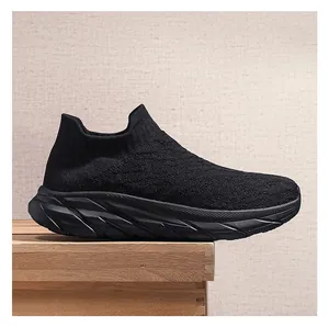 Detailed view of black breathable fly knit fabric and chunky cushioned sole on sports shoe