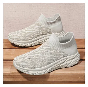 Detail of cream knitted sock sneakers with thick white soles on wooden planks
