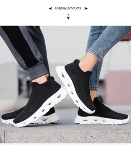 Detail of black knitted sock sneakers showing textured fabric and thick hollowed white soles