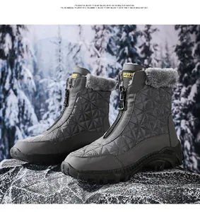 Detalle de botas de nieve grises con cremallera frontal y forro de felpa en rocas