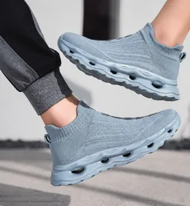 Close-up of light blue grey fly-knit slip-on sneakers with thick hollowed-out soles