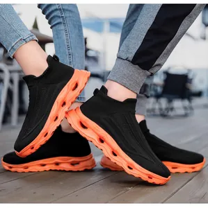 Detail view of black knit upper and bright orange hollow cushioning sole on shoes