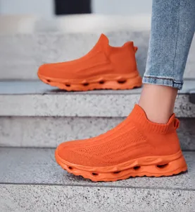 Detail of orange knitted slip-on sneakers with breathable upper and thick hollow sole