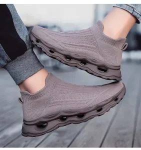 Detail of grey knitted sock sneakers featuring a hollow wavy shock-absorbing sole design