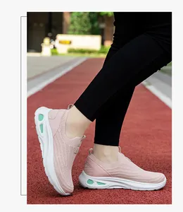 Vue détaillée de baskets roses en maille avec semelles blanches sur une piste
