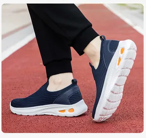 Vue détaillée de baskets en maille marine avec détails orange et semelle blanche