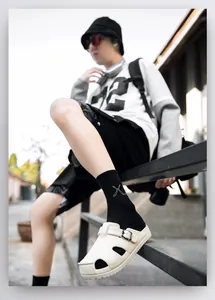 Detail of off-white closed-toe clogs with adjustable metal buckles and thick soles