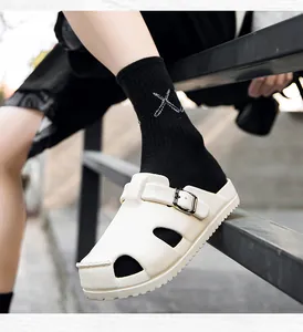 Close-up of white EVA clogs with adjustable metal buckles and breathable side holes