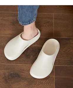 Gros plan de sabots en EVA beige sur parquet montrant la semelle épaisse et souple