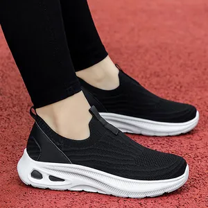 Chaussures de marche en tricot noir respirant avec texture ondulée sur piste rouge