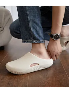 Gros plan de sabots en EVA beige avec semelles épaisses sur un parquet d'intérieur