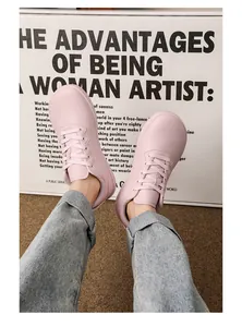 Primo piano di sneakers casual in pelle rosa indossate da una modella in jeans