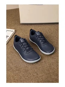 Dettaglio di scarpe casual blu scuro con punta larga e suola piatta bianca resistente