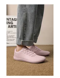 Dettaglio delle scarpe casual rosa stringate abbinate a jeans in denim con risvolto