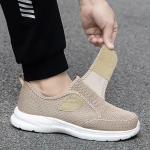 Sneakers beige traspiranti da uomo con ampia chiusura a strappo su sfondo stradale