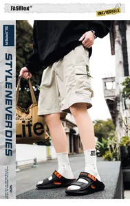 Straßenstil-Ansicht von schwarzen Herren-Sportsandalen mit orangefarbenen Akzenten