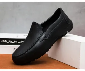 Détail des mocassins en cuir noir grainé avec coutures en U et semelle en caoutchouc