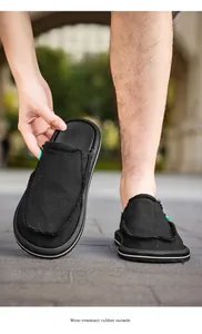 Detail of black canvas mule with frayed edges and wear-resistant rubber outsole