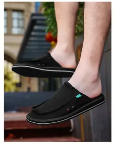 Macro shot of black canvas mule sneaker showing raw edges and side ventilation eyelets
