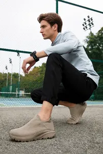 Men's breathable mesh slip-on sneaker in beige with cushioned sole worn on a court
