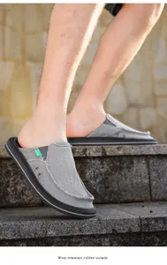 Detail of grey canvas mule shoe with frayed edges and wear-resistant rubber outsole