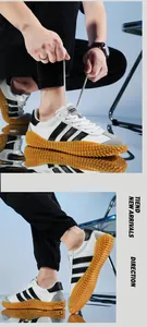 Detail of white mesh and suede sneakers featuring black stripes and studded gum soles