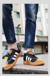 Close-up of black mesh and brown suede sneakers with a classic rubber gum sole