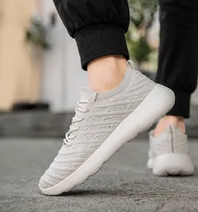 Vue portée de baskets grises en maille respirante avec semelles blanches amortissantes
