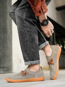 Detail view of breathable grey mesh upper and orange anti-slip sole on casual wide-fit sneakers