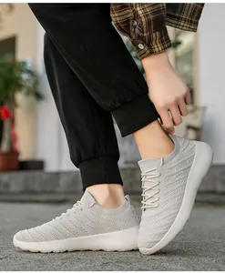 Détail du tissu fly-knit respirant gris clair et texture des baskets de sport hommes