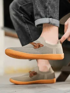 Detailed view of khaki mesh men's slip-on shoe with non-slip orange rubber sole
