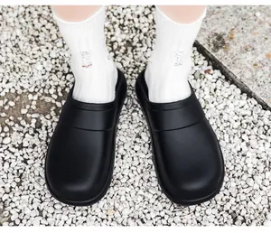 Top view of black lightweight EVA chef shoes on white stones for outdoor kitchen wear