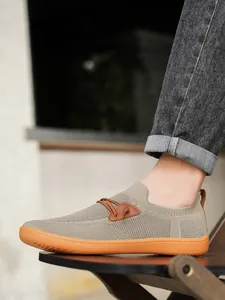 Detail showing breathable mesh fabric and vibrant orange rubber sole of men's casual shoes